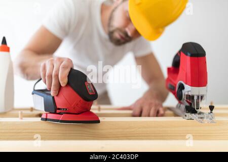 Falegname maschile che lavora su un progetto nella sua officina Foto Stock