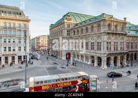Turistico, turistico, autobus rosso parcheggiato da Albertinaplatz, strada trafficata nel centro di Vienna, sullo sfondo dell'opera di Stato di Vienna, Vienna, Austria. Foto Stock