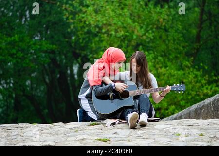 Due giovani ragazze musulmane con classe di chitarra Foto Stock