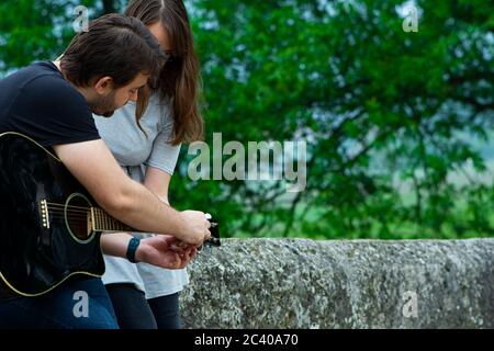 Fratello insegnava a suonare la chitarra in natura Foto Stock