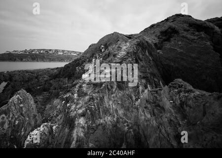 Burgh Island, Devon, Regno Unito. 21 marzo 2016. Il mare si affaccia su rocce ai margini dell'isola. Foto Stock