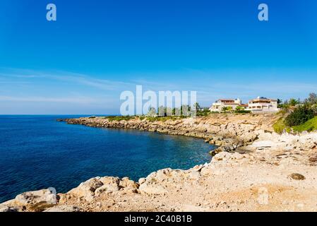 Costa rocciosa di Cipro con hotel in una giornata di sole. Il concetto di turismo e di viaggio. Foto Stock