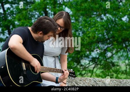Fratello insegnava a suonare la chitarra in natura Foto Stock