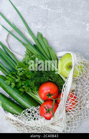 Borsa a filo ecologica con verdure fresche e frutta su un tavolo in pietra. Concetto di stile di vita sostenibile, senza sprechi. Cibo biologico sano. Foto Stock