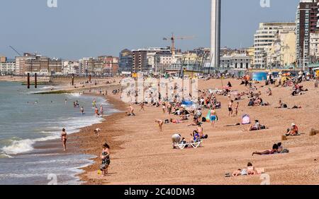 Brighton UK 23 giugno 2020 - oggi le folle si affollano alla spiaggia di Brighton mentre godono il sole caldo . Il tempo è previsto per ottenere ancora più caldo nei prossimi giorni con temperature previste per raggiungere oltre 30 gradi in parti del Sud-Est: Credit Simon Dack / Alamy Live News Foto Stock