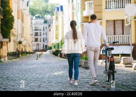 Uomo con moto e donna vista a piedi dal retro. Foto Stock