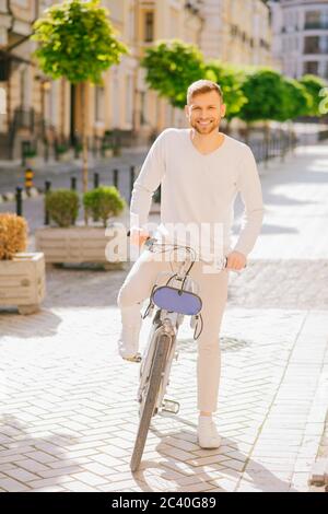 Attraente giovane uomo con la bearded in piedi con una bicicletta. Foto Stock