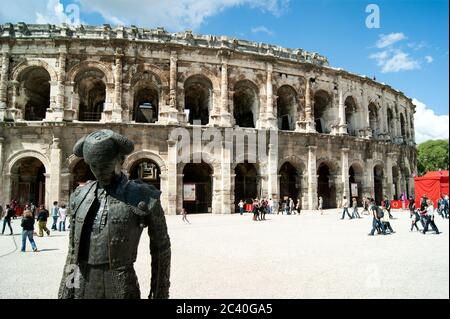 Arena di Nimes, Francia meridionale. Un anfiteatro romano perfettamente conservato. Il teatro è ora utilizzato per la lotta contro i tori, da cui una statua di un Matador Foto Stock