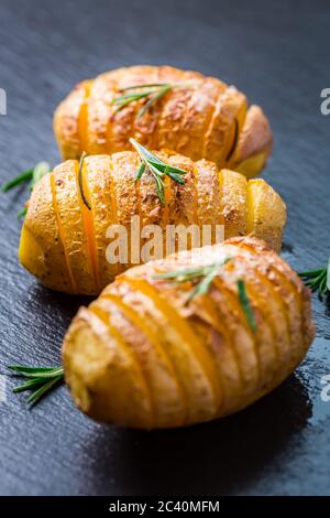 Patate Hasselback. Patate a filetto dalla Svezia con aglio ed erbe grigliate nel forno. Foto Stock