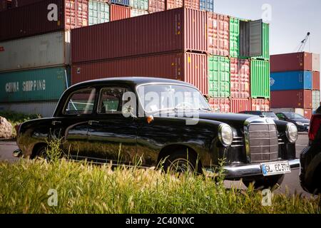 Vecchia Mercedes-Benz 180 (W 120) davanti ai container del porto sul Reno nel quartiere di Niehl, Colonia, Germania. ALTER Mercedes-Benz 180 (W 120 Foto Stock