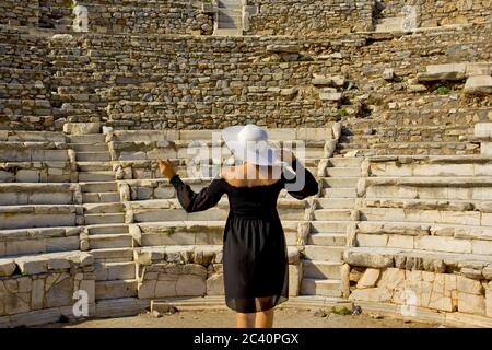 Bella giovane donna in abito nero nella città antica di Efeso Foto Stock
