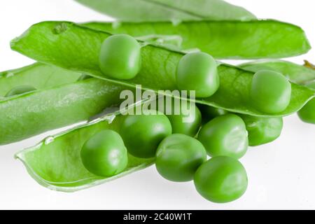 piselli freschi si trovano in un baccello aperto. Isolato su sfondo bianco Foto Stock