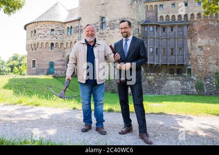 Grevenbroich, Germania. 23 Giugno 2020. Jan Josef Liefers (r), attore (come Karl-Friedrich Boerne) con una stella del mattino con due palle di metallo e Axel Prahl, attore (come Frank Thiel) con un balestra, sono in piedi davanti al Castello di Hülchrath durante le riprese della nuova scena criminale da Münster. Non è stata ancora fissata una data di trasmissione per il Tatort con il titolo di 'Long Live the King' su ARD. Credit: Rolf Vennenbernd/dpa/Alamy Live News Foto Stock