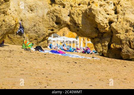 3 ottobre Holiday Makers prendere il sole in una baia deserta lungo la spiaggia di Oura Praia sull'Algarve Portugal vicino Albuferia. Le rocce sono intemperie Foto Stock