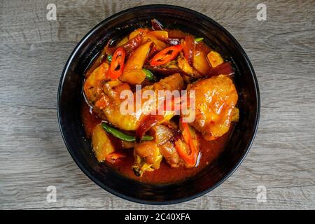 Pollo fritto cotto con salsa piccante dolce e acara, peperoncino tailandese, peperoncino rosso e patate. Foto Stock