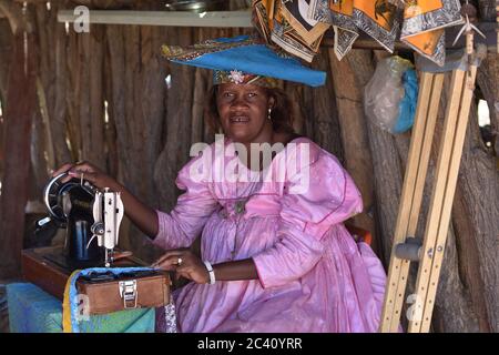 KAOKOLAND, NAMIBIA - 1 FEBBRAIO 2016: Herero Donna non identificata in abiti tradizionali con macchina da cucire. L'Herero appartenente al gruppo Bantu, con Foto Stock