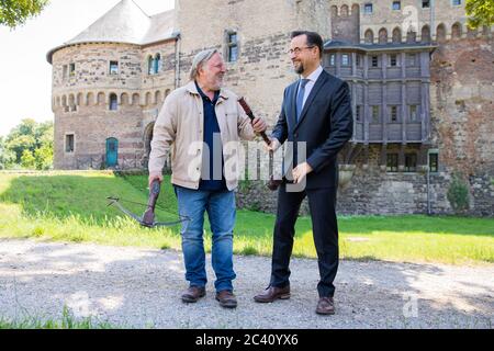 Grevenbroich, Germania. 23 Giugno 2020. ESCLUSIVO - Jan Josef Liefers (r), attore, (come Karl-Friedrich Boerne) con una stella mattutina con due palle di metallo e Axel Prahl, attore, (come Frank Thiel) con un balestra, sono in piedi davanti al Castello di Hülchrath durante le riprese del nuovo 'Tatort' da Münster. Non è stata ancora fissata una data di trasmissione per il Tatort con il titolo di 'Long Live the King' su ARD. Credit: Rolf Vennenbernd/dpa/Alamy Live News Foto Stock