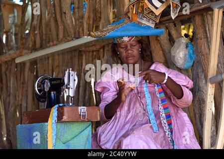 KAOKOLAND, NAMIBIA - 1 FEBBRAIO 2016: Herero Donna non identificata in abiti tradizionali con macchina da cucire. L'Herero appartenente al gruppo Bantu, con Foto Stock