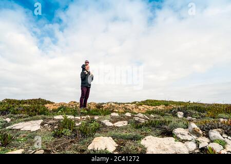 Padre e piccolo figlio piggybacked che camminano nella natura, Portogallo Foto Stock