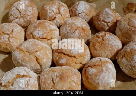 Pasta di mandorle dolci e farina per preparare questi biscotti fatti in casa amaretti da servire con caffè. Mostrato appena fresco fuori dal forno su carta da forno. Foto Stock