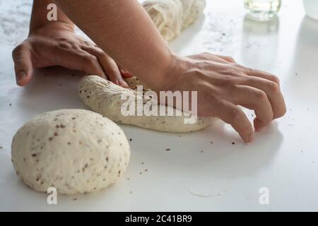 Uomo che impastano un impasto grande per il pane fatto in casa in quarantena Foto Stock