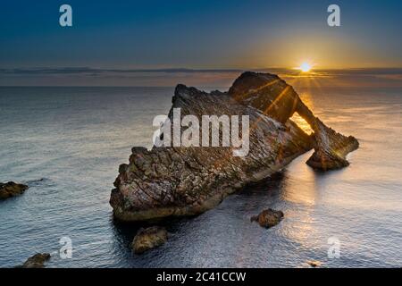 BOW FIDDLE ROCK PORTKNOCKIE MORAY COAST SCOZIA FINE GIUGNO PRIMI ALBA CON I RAGGI DEL SOLE SULLA PARETE ROCCIOSA Foto Stock