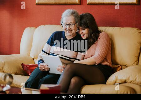 nipote e nonna che guardano qualcosa sul tavolo Foto Stock