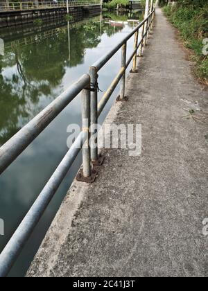 Percorso a piedi in cemento lungo il canale di drenaggio Foto Stock