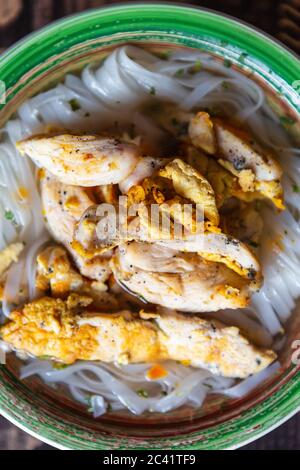 Zuppa asiatica di ramen con strisce di pollo. Tradizionali tagliatelle di riso vietnamite bollite in brodo di pollame con erbe e spezie per cena. Delizioso pranzo cibo f Foto Stock