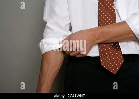 L'uomo rotola la sua camicia manica - abbigliamento - business Foto Stock