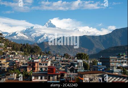 Il paesaggio urbano di Pokhara con la catena montuosa dell'Annapurna coperta di nubi e neve nel Nepal centrale, in Asia Foto Stock