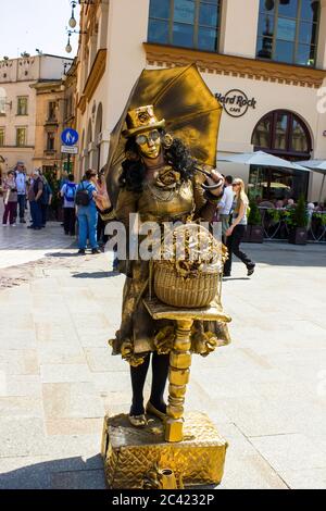 Cracovia, Polonia - 23 MAGGIO 2014: Un artista di strada vestito d'oro per vivere per attrarre il turista nel centro della città - Europa Foto Stock