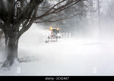 spazzaneve che soffia neve dal vialetto durante la bizzarda Foto Stock