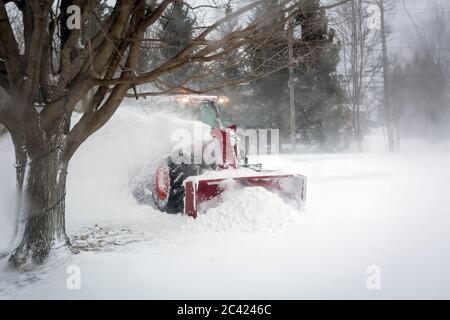 Spazzaneve che soffia neve dal vialetto durante Blizzard, Meaford, Ontario, Canada Foto Stock