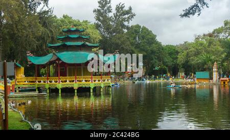 Inmaculada Concepcion de Loja, Loja / Ecuador - Marzo 31 2019: Turisti che si addormentano in barca vicino a una riproduzione di una pagoda cinese nella laguna del Foto Stock