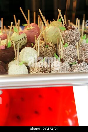 Mele al cioccolato su spiedini su un vassoio Foto Stock