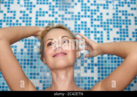 Donna di mezza età fa una doccia Foto Stock