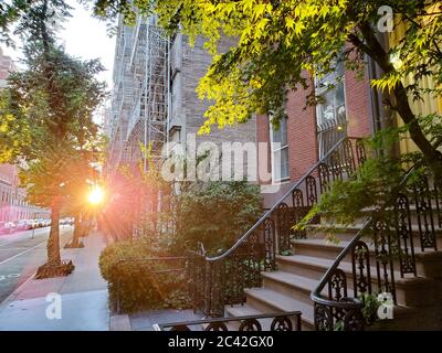 New York City - la luce del sole splende sugli edifici lungo una strada tranquilla nel quartiere Greenwich Village di Manhattan a New York Foto Stock