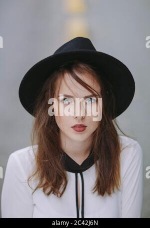 Ritratto di giovane donna dagli occhi blu con cappello nero Foto Stock