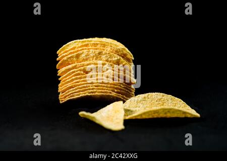 Patatine deliziose e croccanti, isolate su sfondo nero Foto Stock