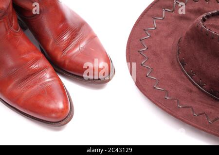 Concetto di Wild West, stivali e cappello da cowboy isolati su sfondo bianco Foto Stock