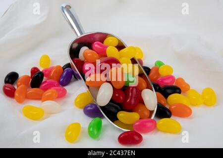 un bicchiere di fagioli di gelatina colorati su uno sfondo di stoffa Foto Stock