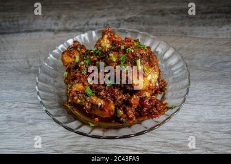 Succulenta carne di pollo con salsa Balado piccante e fragrante. La pasta di Balado è fatta con ingredienti come peperoncino rosso, aglio e scalogni. Foto Stock