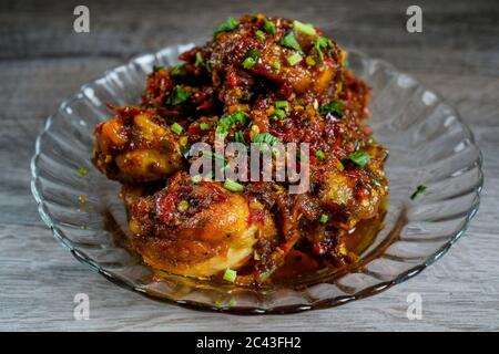 Succulenta carne di pollo con salsa Balado piccante e fragrante. La pasta di Balado è fatta con ingredienti come peperoncino rosso, aglio e scalogni. Foto Stock