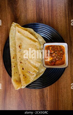 Chapati con curry di pollo mescolare con sambal di sardina. Foto Stock