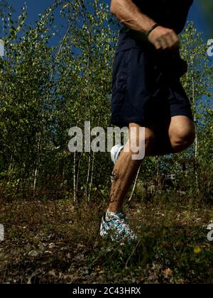 Uomo che fa jogging in una zona rurale, Monaco, Baviera, Germania Foto Stock