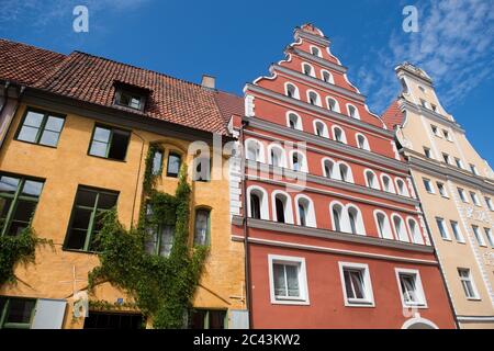 15 giugno 2020, Meclemburgo-Pomerania occidentale, Stralsund: Vista di una fila di case nel centro storico di Stralsund, nella via dei traghetti. La città anseatica di Stralsund, menzionata per la prima volta nel 1234, è uno dei magneti turistici del Meclemburgo-Vorpommern a causa degli oltre 500 edifici elencati, la maggior parte dei quali è stata ampiamente restaurata negli ultimi anni con la società di trustee revelopment Stadterneuerungsgesellschaft Stralsund mbH (SES). Nel giugno 2002, il centro storico medievale di Stralsund è stato incluso nella lista dei siti Patrimonio dell'Umanità dell'UNESCO insieme alla Città anseatica di Wismar. Foto Stock