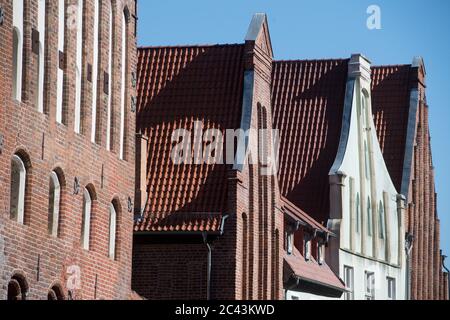 15 giugno 2020, Meclemburgo-Pomerania occidentale, Stralsund: Vista di una fila di case nel centro storico di Stralsund, nella Mühlenstraße. La città anseatica di Stralsund, menzionata per la prima volta nel 1234, è uno dei magneti turistici del Meclemburgo-Vorpommern a causa degli oltre 500 edifici elencati, la maggior parte dei quali è stata ampiamente restaurata negli ultimi anni con la società di trustee revelopment Stadterneuerungsgesellschaft Stralsund mbH (SES). Nel giugno 2002, il centro storico medievale di Stralsund è stato incluso nella lista dei siti Patrimonio dell'Umanità dell'UNESCO insieme alla Città anseatica di Wismar. PH Foto Stock