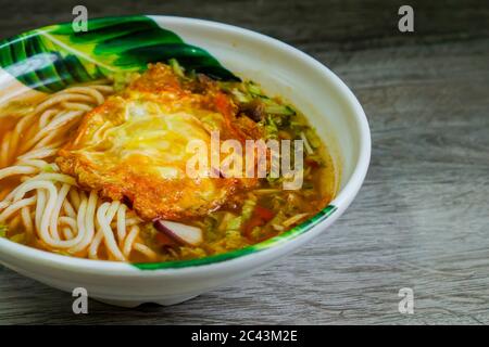 Tradizionale laksa della Malesia settentrionale con un piccolo tocco di originalità. Servire con uova fritte invece di uova bollite. Foto Stock