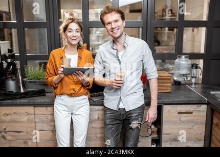 Due giovani manager o proprietari di negozi che hanno qualche discussione nel negozio o caffè. Concetto di gestione delle piccole imprese Foto Stock